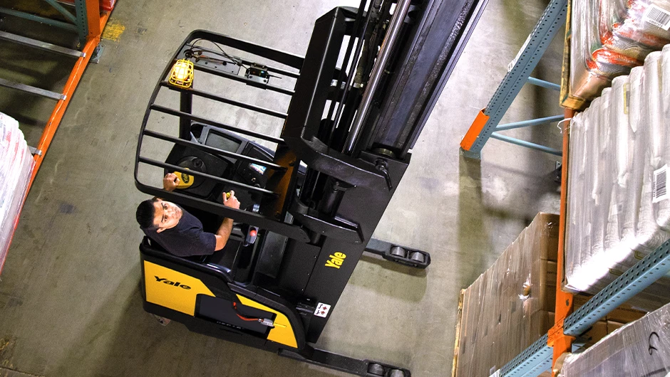 Person operating Yale reach truck in warehouse. 